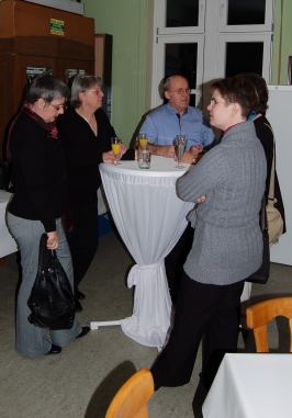 Besucher stehen im Gespräch um einen Stehtisch